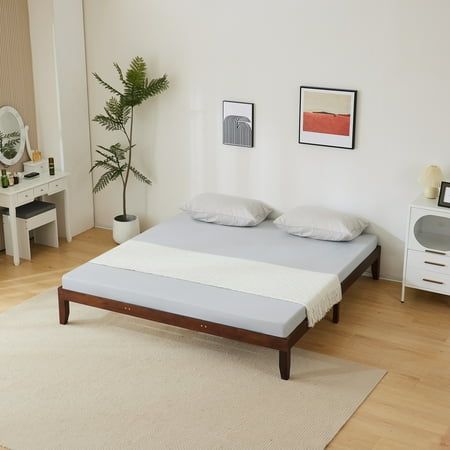 a bedroom with white walls and wooden floors