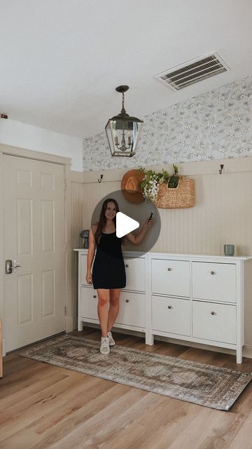 a woman standing in front of a white dresser