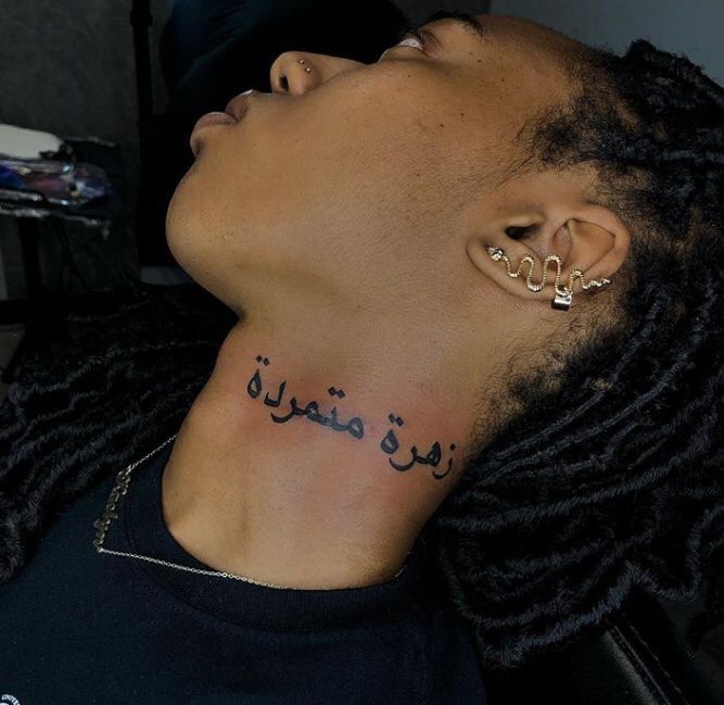 a man with his face covered in ear piercings and writing on the side of his neck