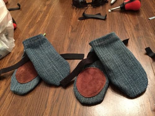 two pairs of mitts sitting on top of a wooden floor