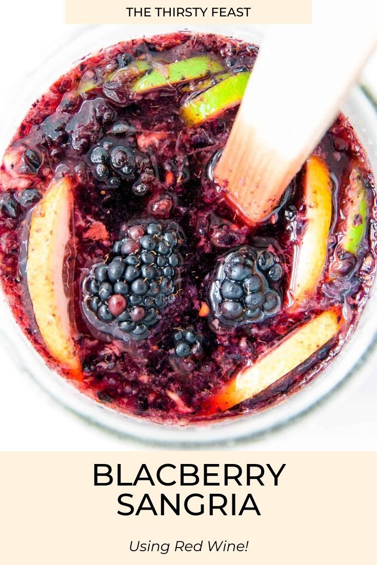 blackberry sangria in a white bowl with a wooden spoon on the side and text overlay that says blackberry sangria using red wine