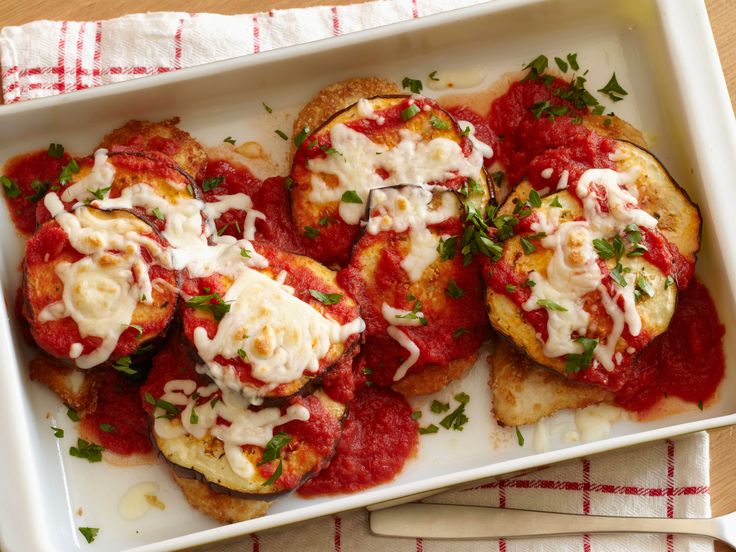 some food is on a white plate with red sauce and parmesan toppings