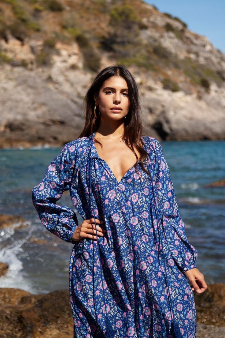 The Bella kaftan is made of light cotton silk voile and printed with vibrant florals. It has a lightweight, airy silhouette with long sleeves, button closure, and a tassel detail. This bohemian kaftan is the epitome of boho-chic style and is as elegant as it is comfortable. Long Sleeve Floral Print Dress For Beachwear, Long Sleeve Boho Dress With Floral Print, Bohemian Long Sleeve Kaftan For Festival, Bohemian Long Sleeve Ikat Print Kaftan, Bohemian V-neck Tunic With Floral Print, Long Sleeve Boho Dress As Beach Cover-up For Spring, Long-sleeved Floral Beach Dress, Long Sleeve Boho Dress For Spring Beach Cover-up, Long Sleeve Floral Beach Dress Cover-up