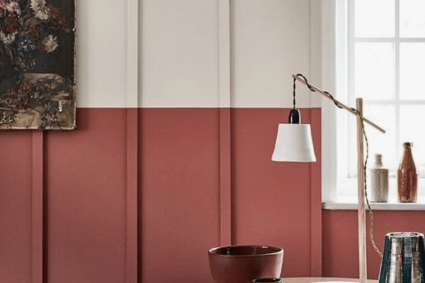 a living room with red walls and white trim on the wall, along with a painting