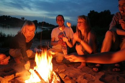 a group of people sitting around a campfire