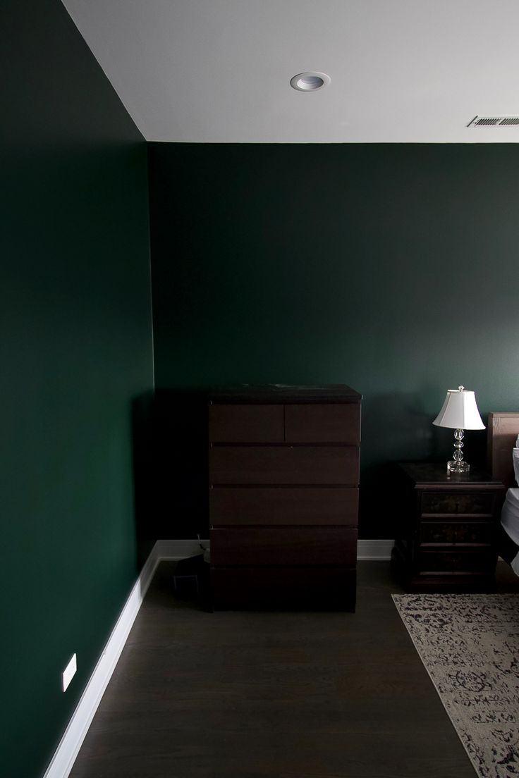 a bedroom with green walls and a white bed in the middle, along with two nightstands