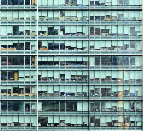 the side of an office building with lots of windows and balconies on each floor