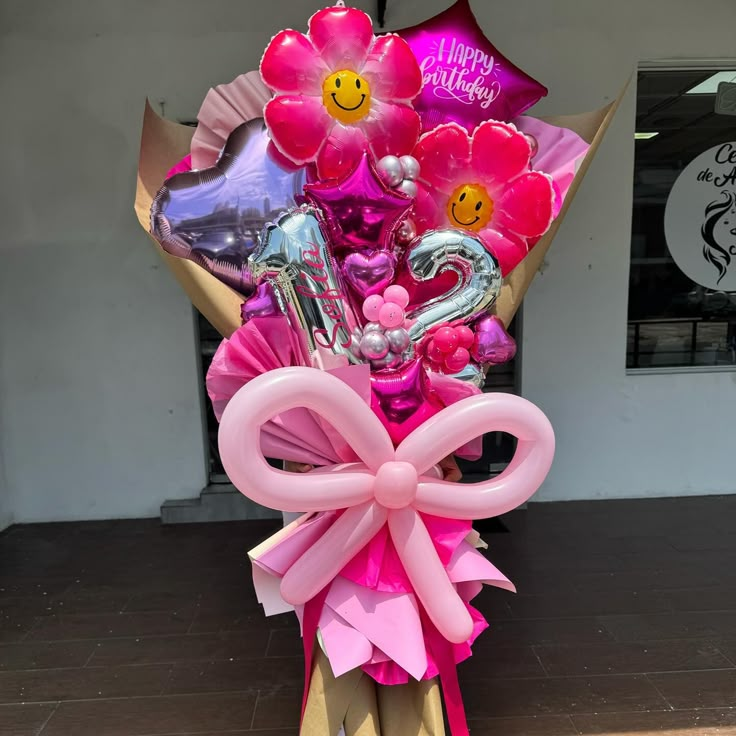 a bouquet of balloons and heliums in front of a storefront with the words happy birthday written on it