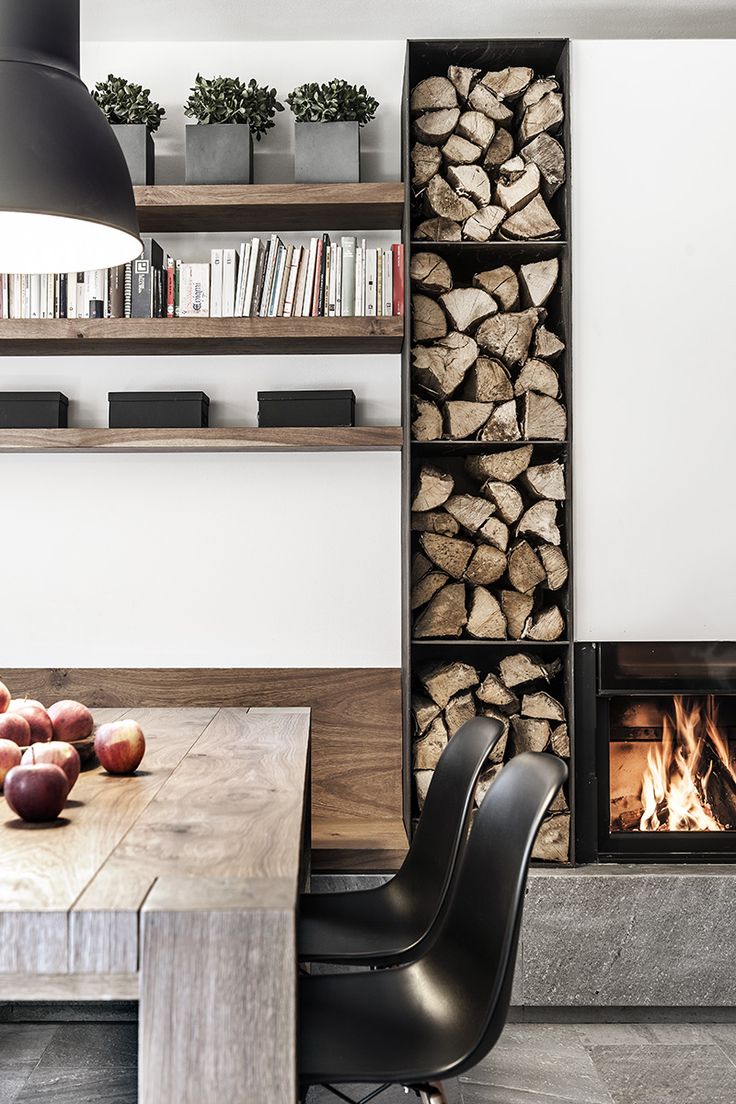 a dining room table with two chairs and a fire place