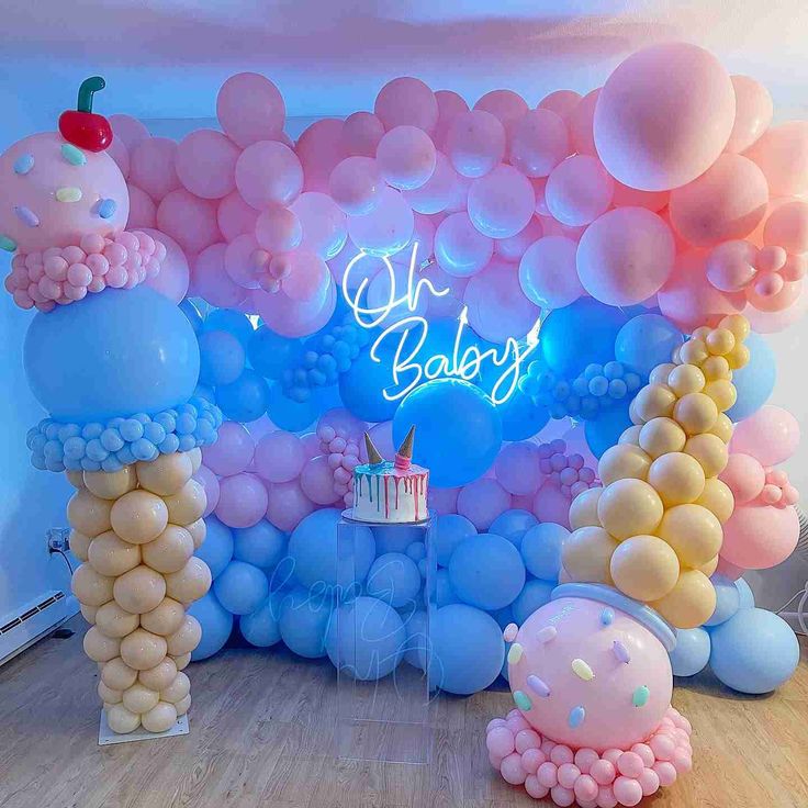 an image of a birthday party setting with balloons and cake on the table in front of it