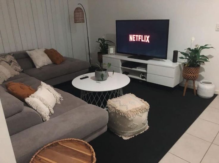 a living room filled with furniture and a flat screen tv on top of a wall