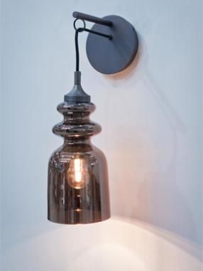 a wall light that is on the side of a wall with a bulb attached to it