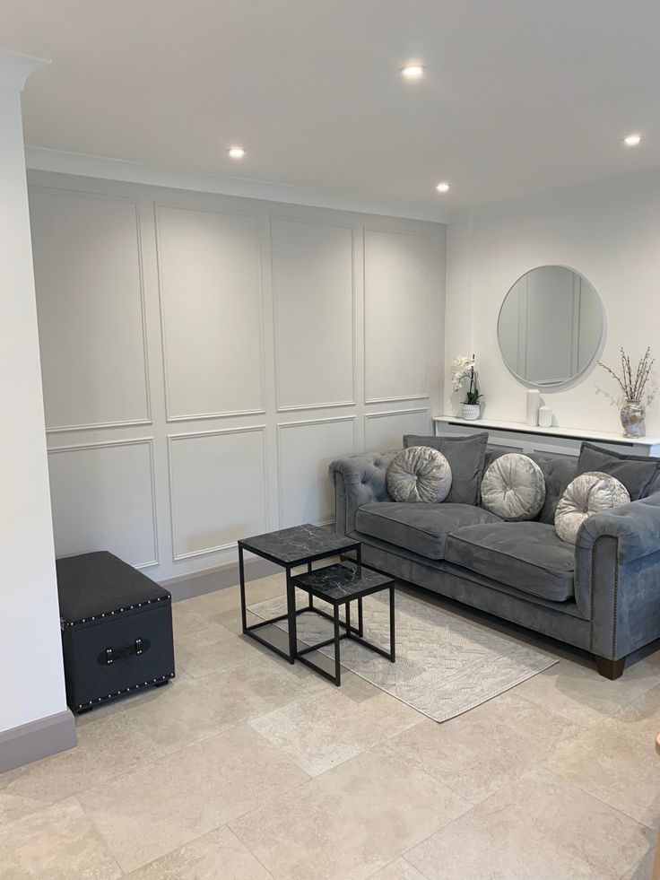 a living room filled with furniture and a large mirror on the wall above it's headboard