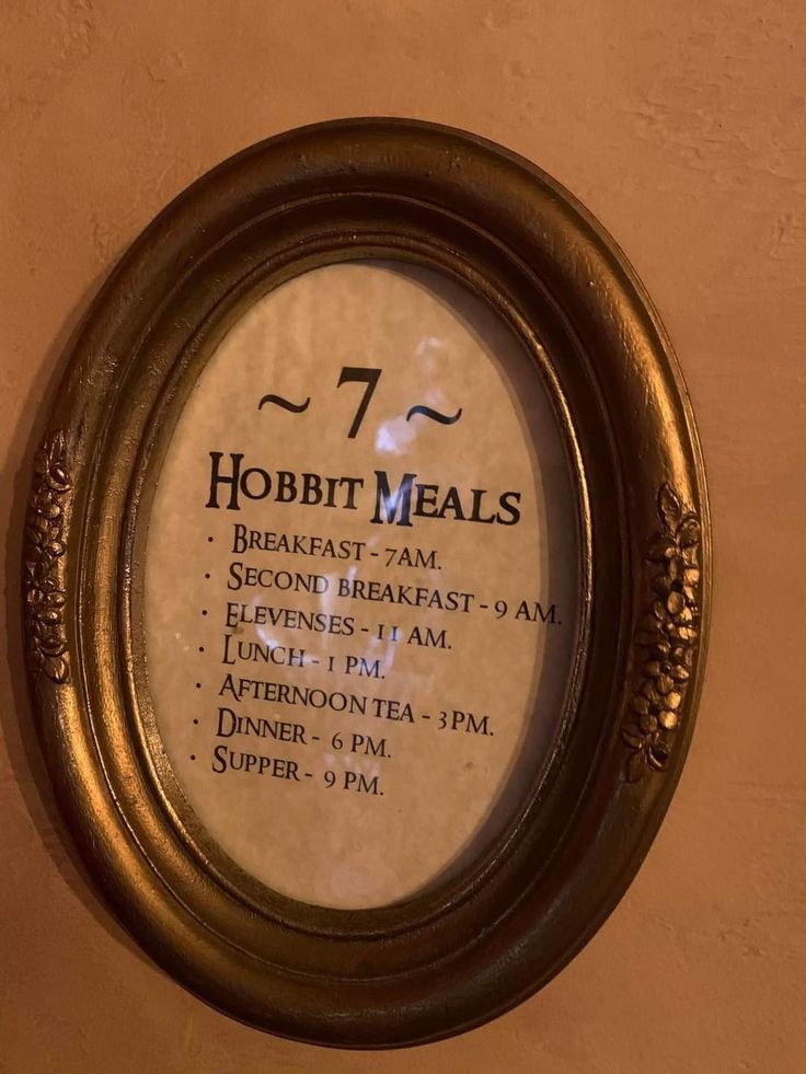 a sign for hobbit meals hanging on the wall