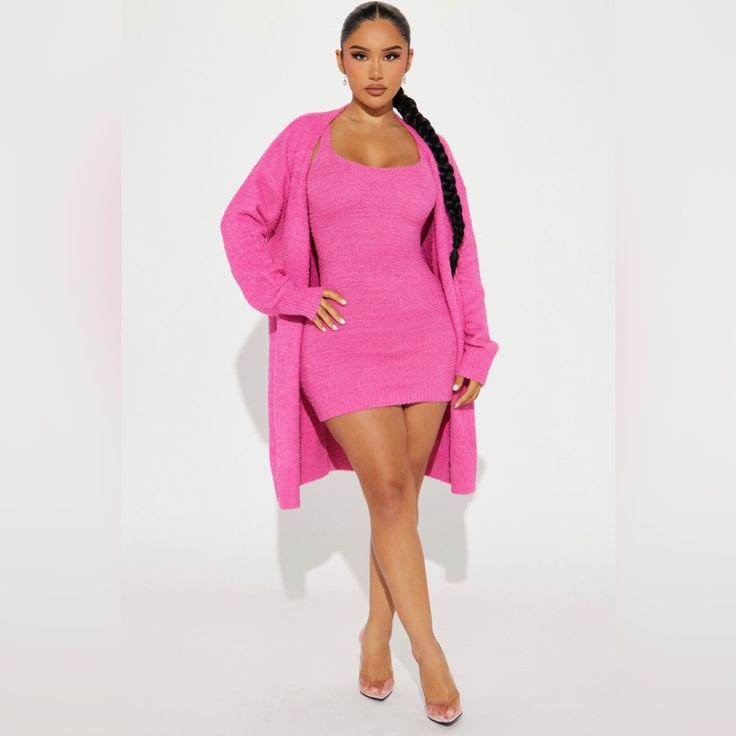 a woman in a pink sweater dress and high heeled sandals poses for the camera