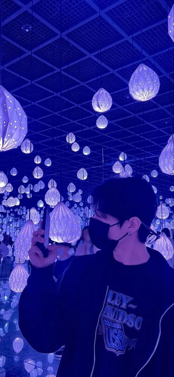 a man standing in front of a room filled with paper lanterns