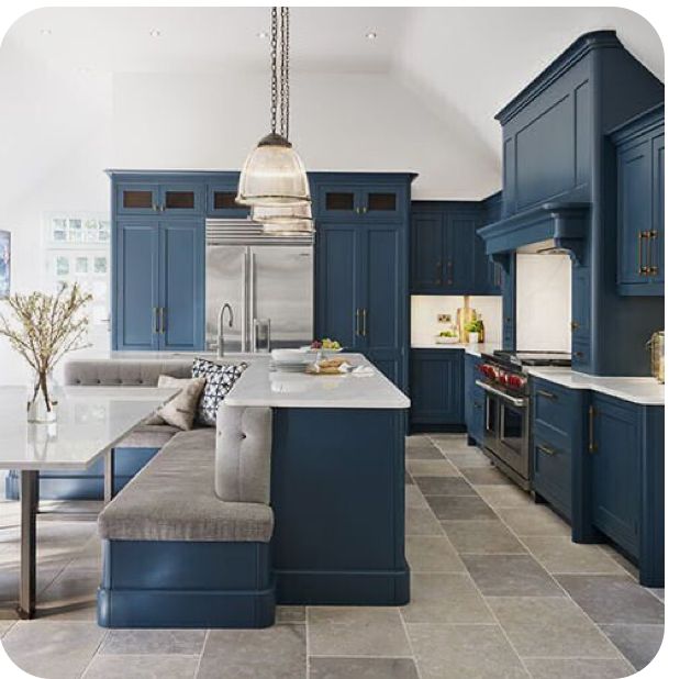 a large kitchen with blue cabinets and white counter tops, along with a gray couch