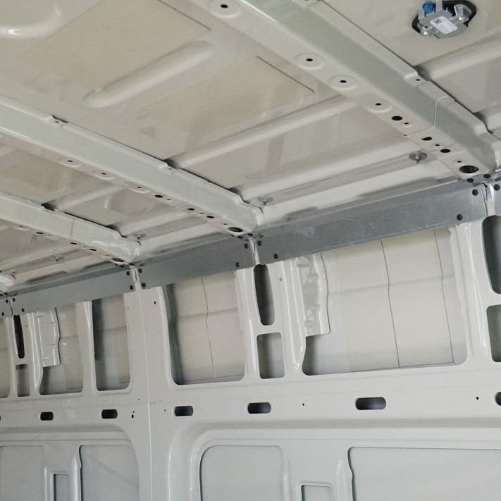 the inside of a van with white walls and metal brackets on the ceiling is shown