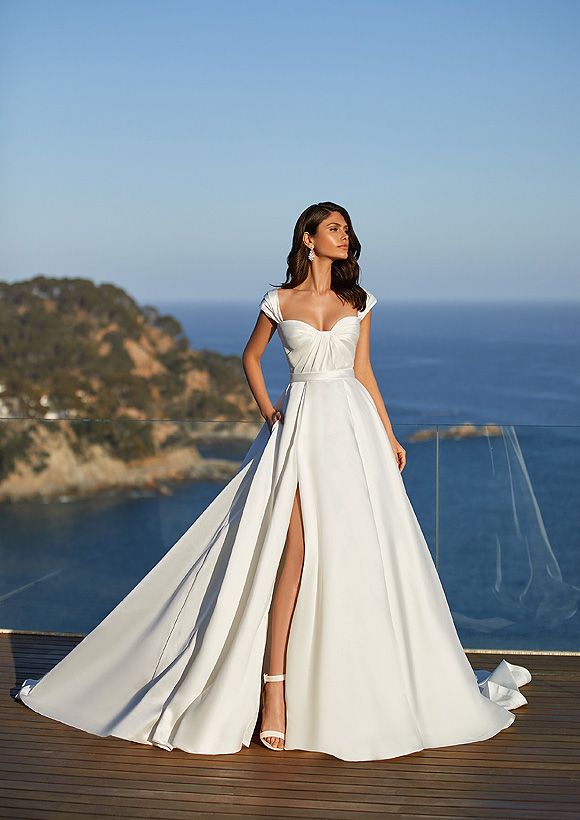 a woman in a white dress standing on a deck