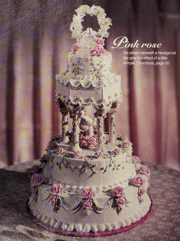 a white wedding cake with pink roses on it