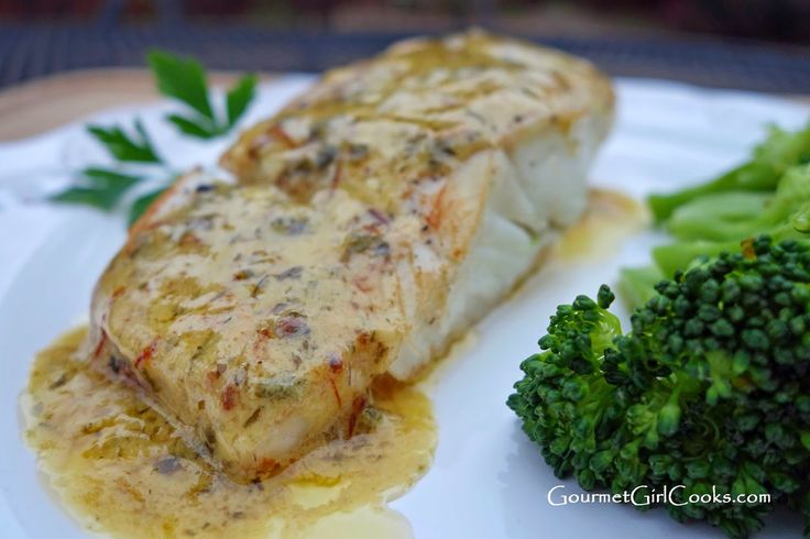 a white plate topped with fish and broccoli