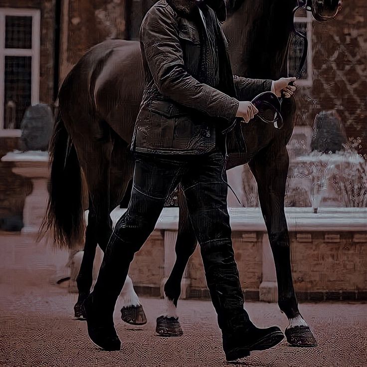 a man is walking his horse in the street with it's bridle on