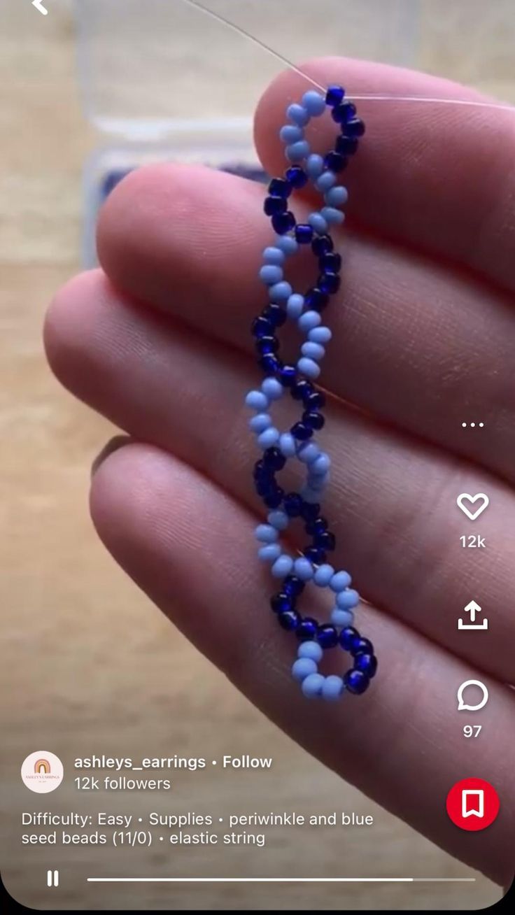 a hand holding a beaded necklace in it's left hand and the beads are blue