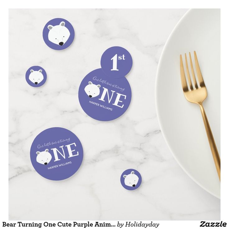 a white plate topped with blue stickers next to a fork and silver utensil