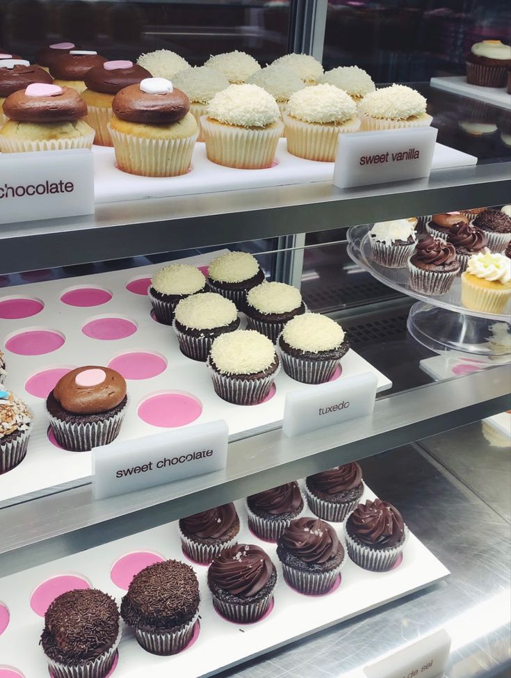 a display case filled with lots of different types of cupcakes