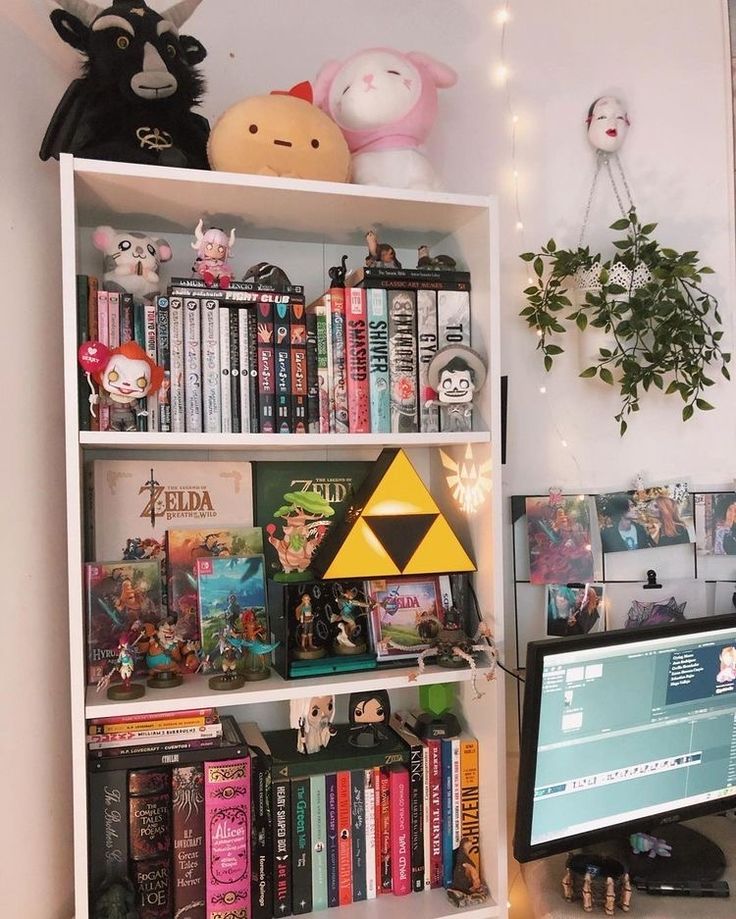 a book shelf filled with lots of books next to a computer monitor on top of a desk