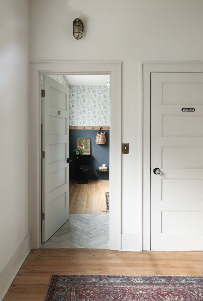 an empty room with two doors and a rug on the floor