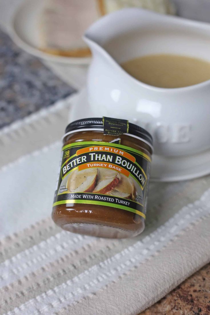 a jar of peanut butter sitting on top of a table next to a bowl of soup