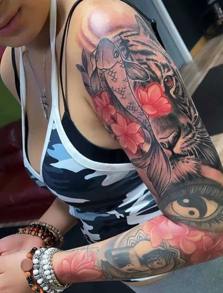 a woman with a tiger and flower tattoo on her arm is holding a cell phone