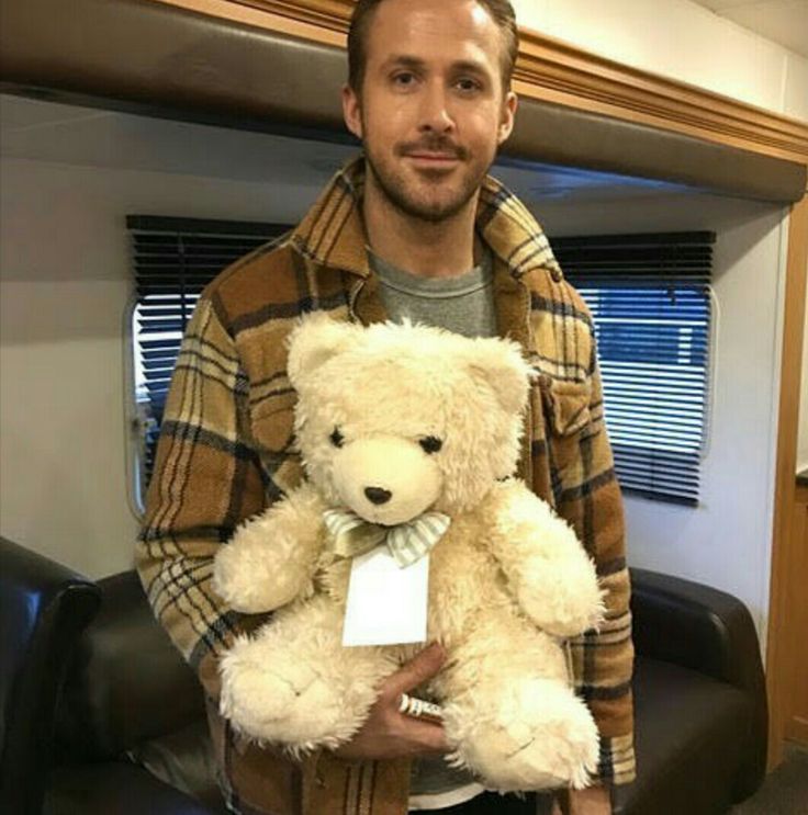 a man holding a teddy bear in his hands