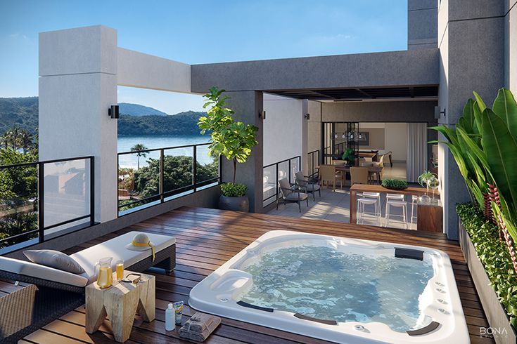 a hot tub sitting on top of a wooden deck next to a patio with an ocean view