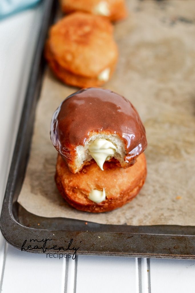 chocolate covered donuts sitting on top of a baking sheet