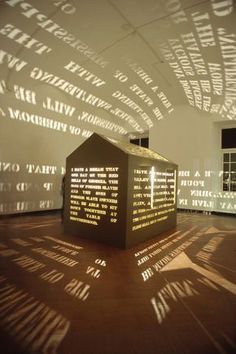 a shadow cast on the wall by a sculpture in a room with windows and shadows