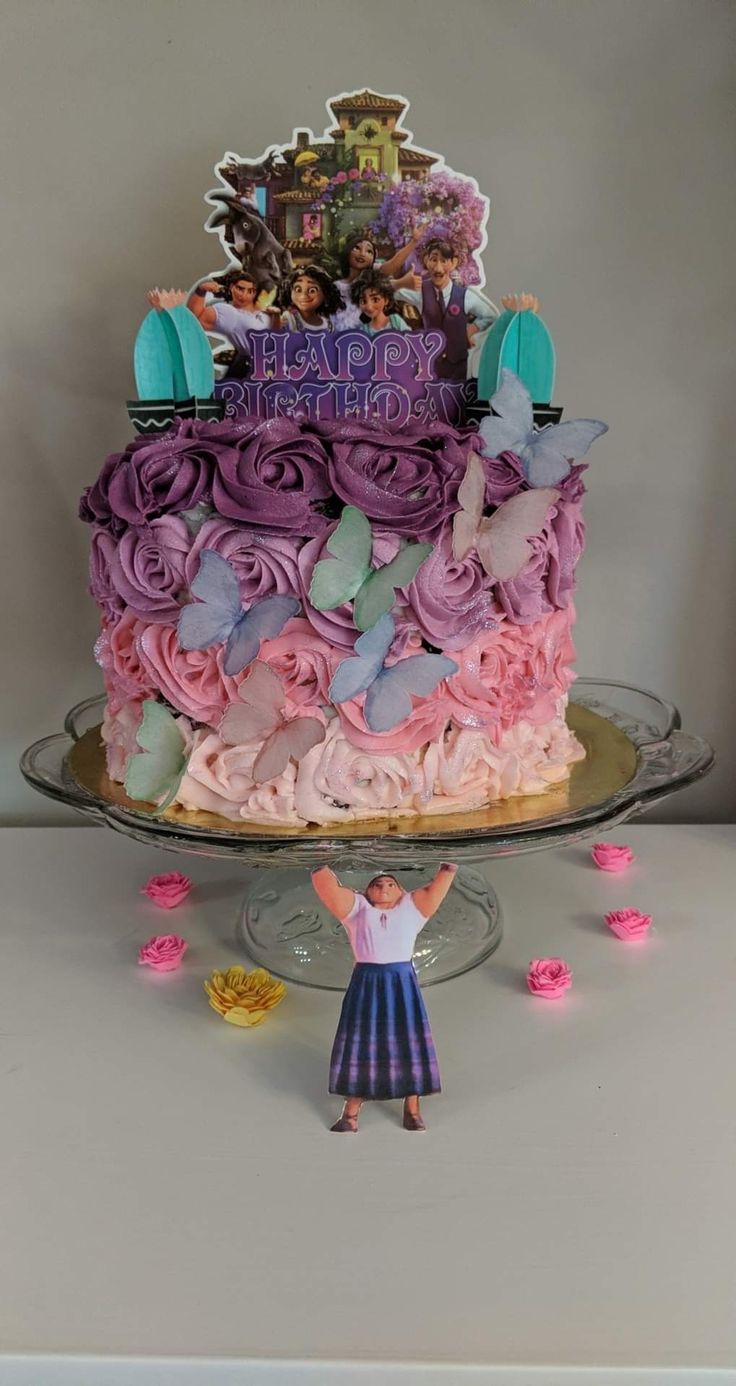 a birthday cake decorated with pink and purple icing