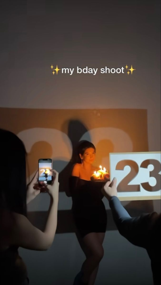 two women are taking pictures with their cell phones while holding candles in front of them