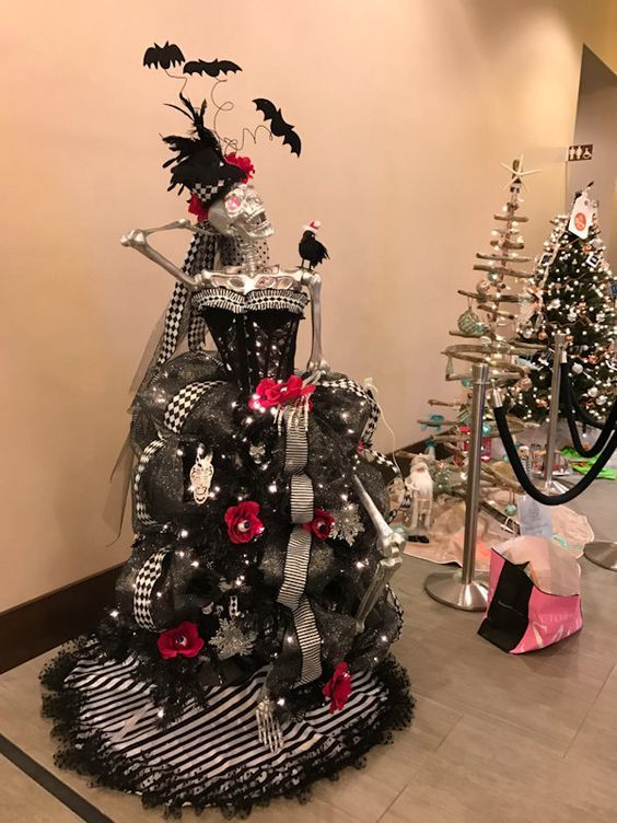 a black and white christmas tree decorated with red flowers, bats and skulls on it