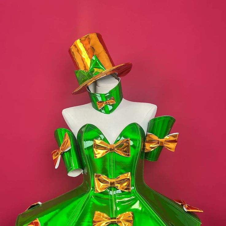 a mannequin dressed in green and gold with a top hat on her head