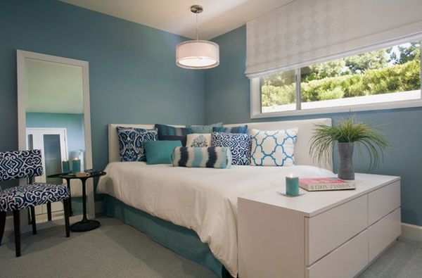 a bedroom with blue walls and white furniture