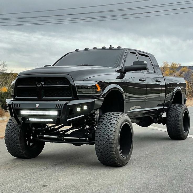 a large black truck is parked on the street