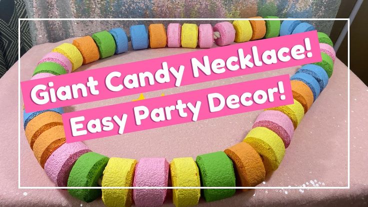 there is a pink sign that says giant candy necklace easy party decor on the table