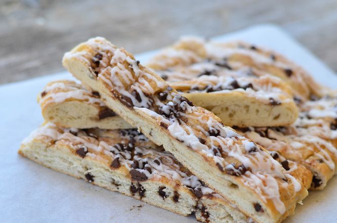 three pieces of chocolate chip pastry sitting on top of a piece of white parchment paper