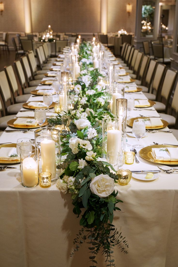 a long table with candles and flowers on it is set up for an elegant dinner