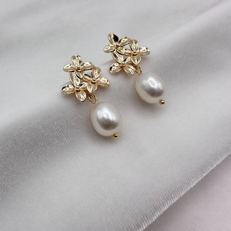 HIGH-LUSTER HANDPICKED WHITE FRESHWATER PEARL FLORAL EARRINGS FOR WOMEN - THE AAA QUALITY, GIA-CERTIFIED GENUINE PEARL EARRINGS YOU CAN TRUST!  -------------------------------------------------------- These floral pearl drop earrings feature AAAA quality dangling freshwater pearls and a beautiful 925 silver floral post, gold-plated with the finest 18K yellow gold. The pearls have a smooth, natural white surface that is glowing, and the gold is designed with a flower-like pattern that encases the Formal Flower-shaped Pearl Drop Jewelry, Elegant Formal Pearl Earrings With Flower Shape, Elegant Flower-shaped Pearl Earrings For Formal Occasions, Gold Flower Shaped Bridal Earrings, Gold Flower Shape Bridal Earrings, Elegant Flower-shaped Formal Earrings, Elegant Gold Flower-shaped Bridal Earrings, Elegant Formal Flower-shaped Pearl Earrings, Gold Flower Earrings For Formal Occasions