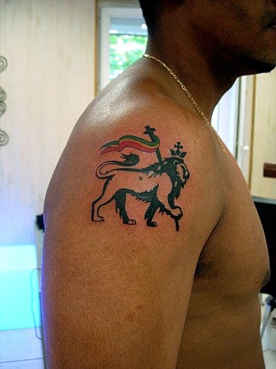 a man with a lion tattoo on his arm and chest is looking at the camera