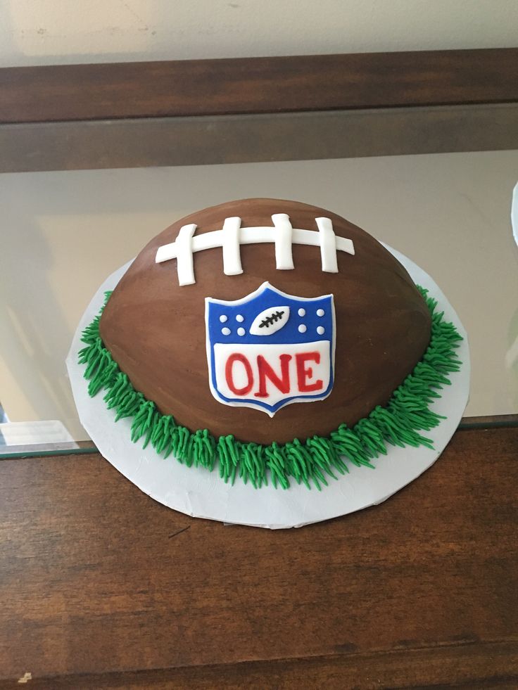 a cake shaped like a football with the number one on it is sitting on a table