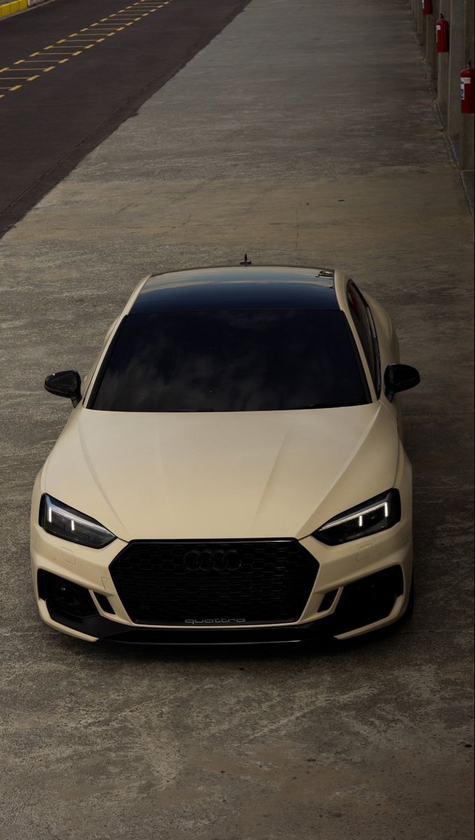 a white car parked on the side of a road next to an empty parking lot